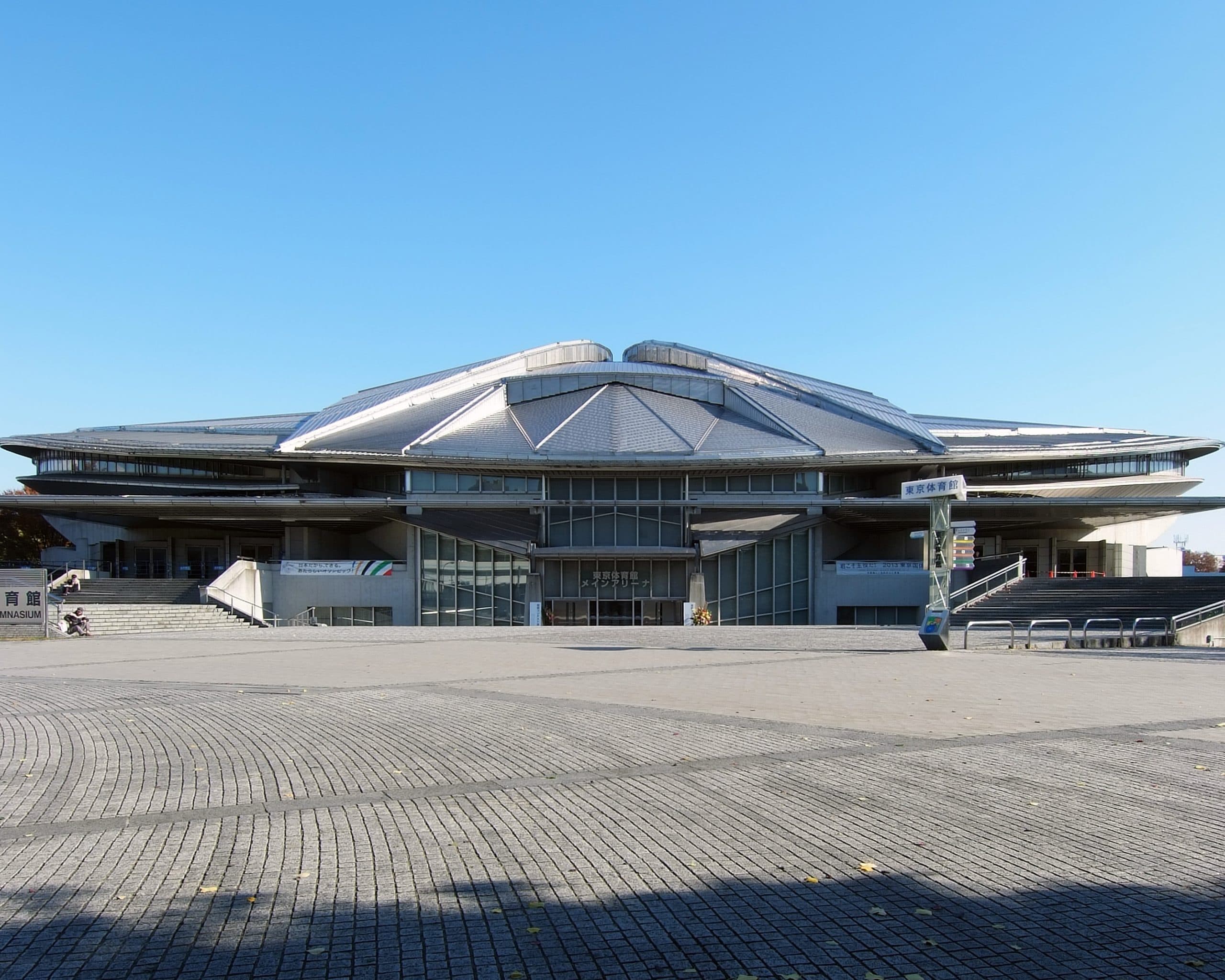 Tokyo Metropolitan Gymnasium byggnad under en klarblå himmel.