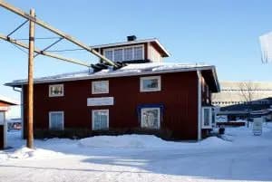 Byggnad med skylt för Clas Ohlson museet i Insjön, täckt av snö.