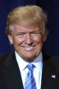 Donald Trump ler och bär en blå slips.