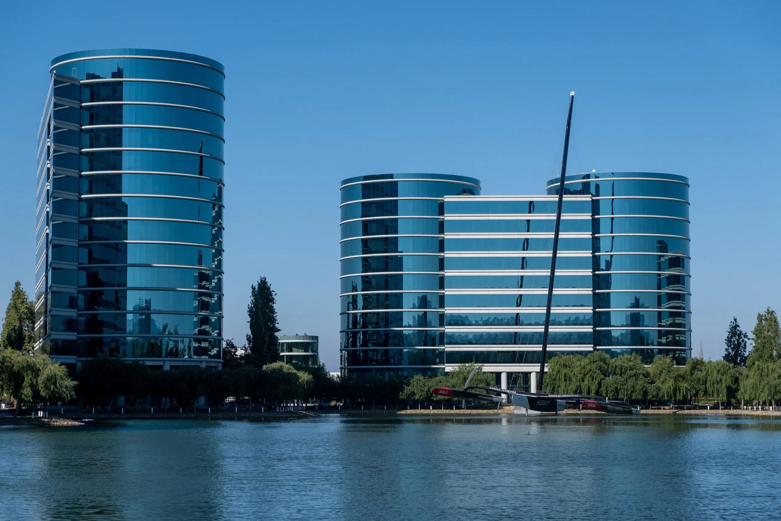 Oracle Corporations huvudkontor med moderna byggnader och en båt i förgrunden.