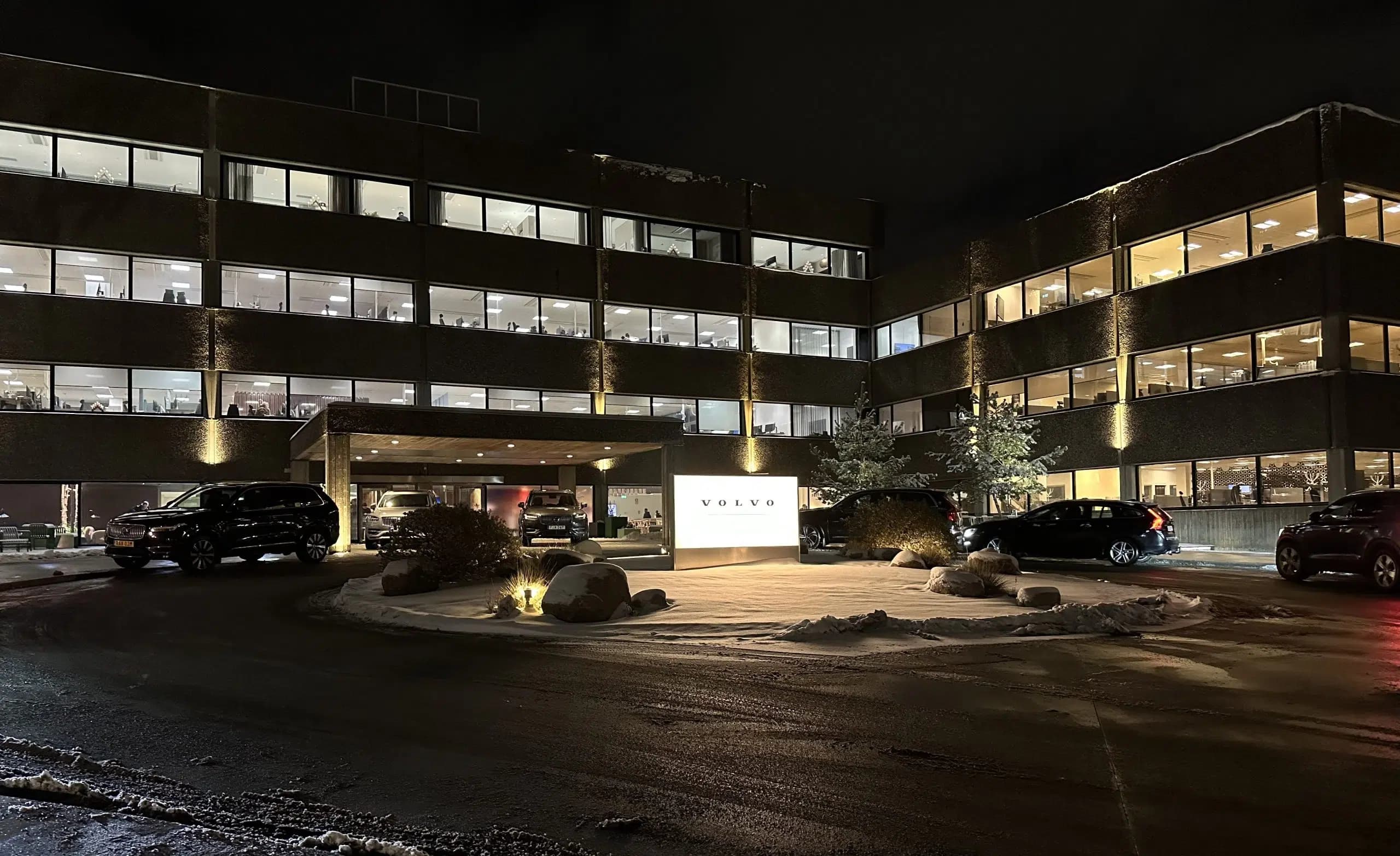 Volvo Cars huvudkontor på natten med bilar parkerade utanför.